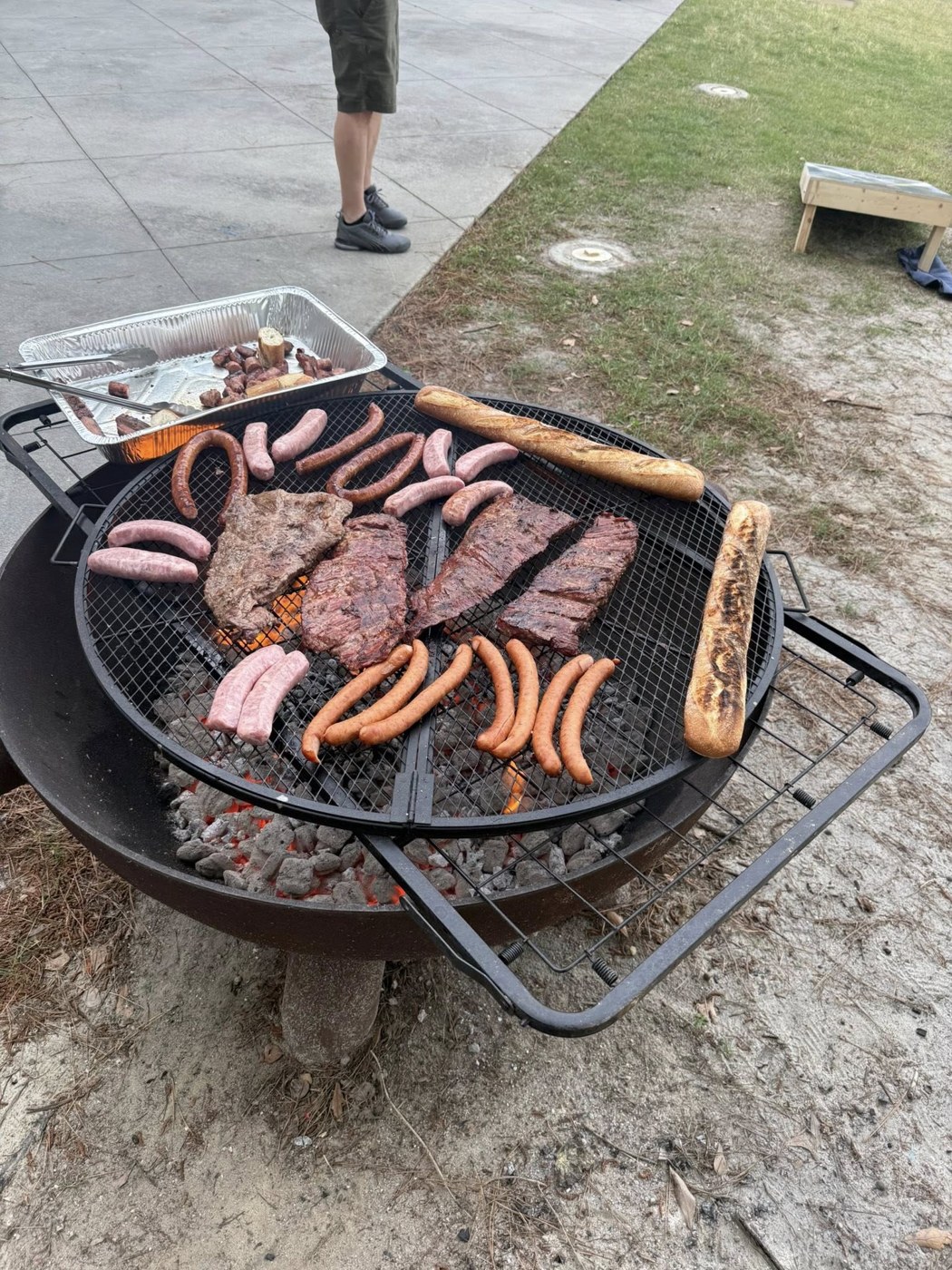 Meat and sausages cooking on an outdoor charcoal grill